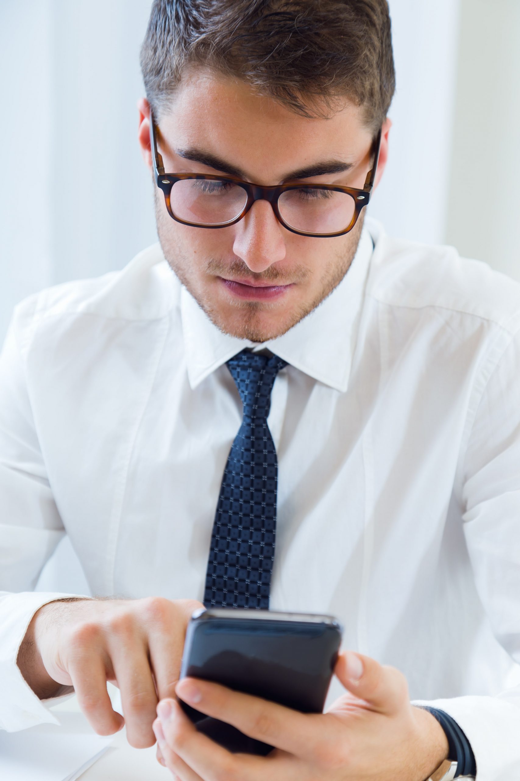 jeune-homme-beau-travaillant-dans-son-bureau-telephone-mobile-min